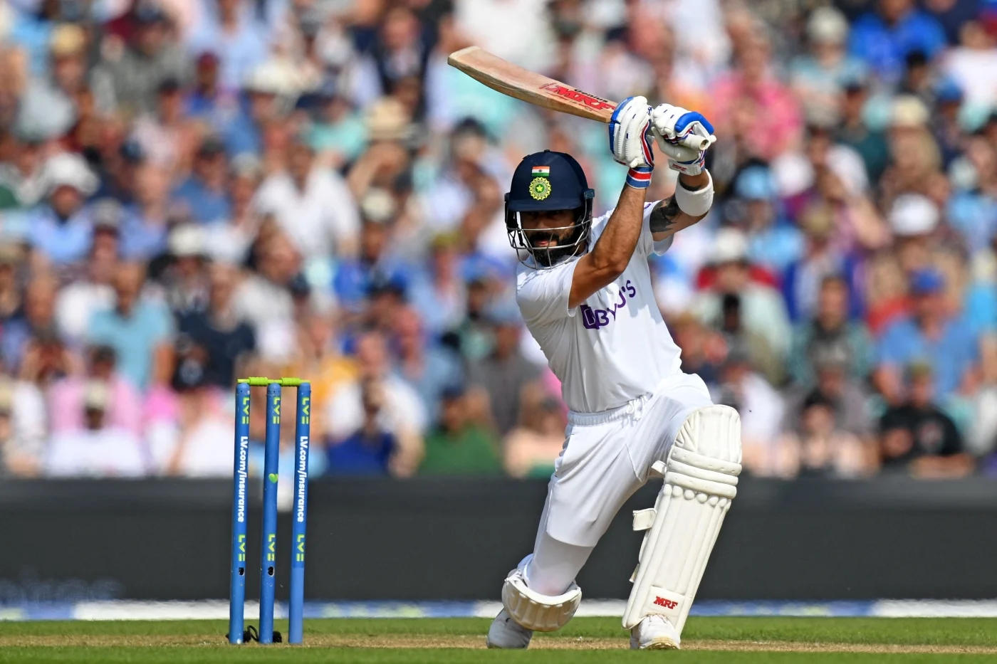 Batter in white cricket kit playing a shot during a match