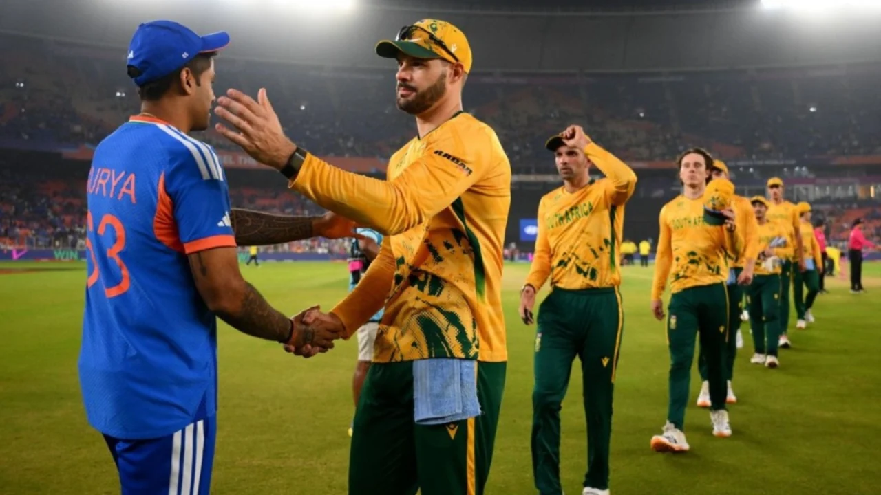 Players in India and South Africa kits greeting each other on a cricket field
