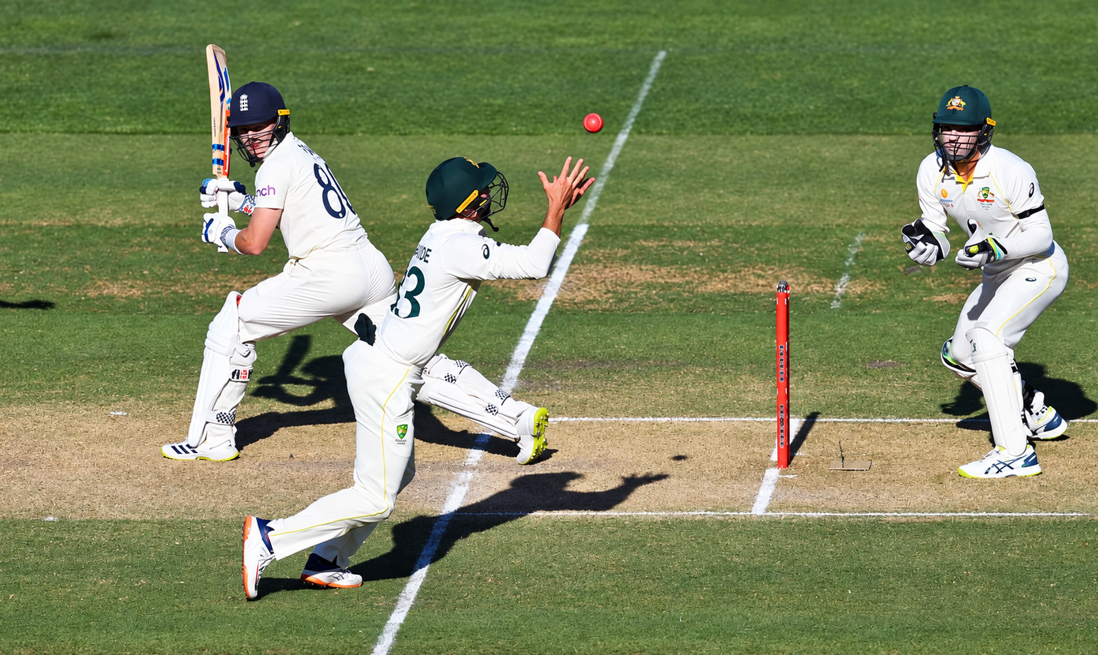 Cricket batter, close fielder and wicketkeeper during a catching chance