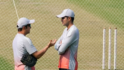 Two cricketers talking beside practice nets and stumps