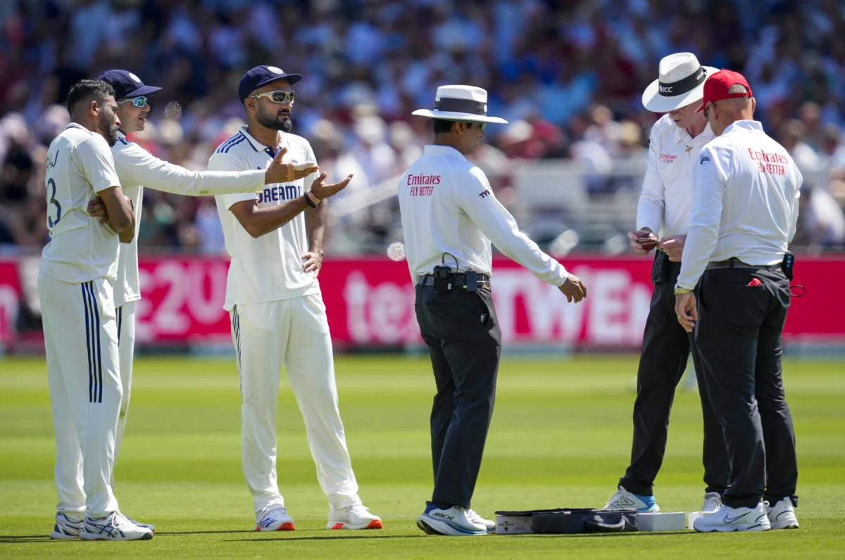 Cricketers and match officials discussing a cricket ball on the field