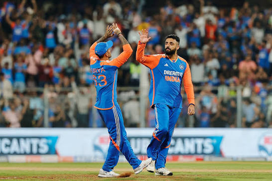Two India cricketers celebrating with raised hands on the field